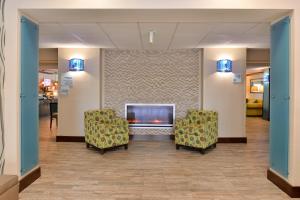 una sala de espera con 2 sillas y chimenea en Holiday Inn Express Fresno River Park Highway 41, an IHG Hotel en Fresno