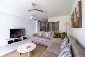 
a living room filled with furniture and a fireplace at Silkari Lagoons Port Douglas in Port Douglas

