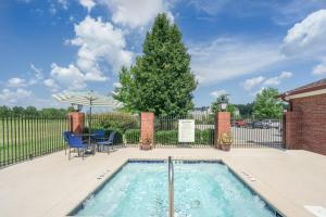 a pool with a table and chairs next to a fence at Holiday Inn Express Hotel & Suites- Gadsden, an IHG Hotel in Gadsden