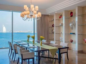 a dining room with a table and chairs and the ocean at Rixos The Palm Hotel & Suites - Ultra All Inclusive in Dubai