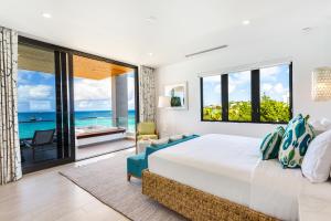 a bedroom with a bed and a view of the ocean at Tranquility Beach Anguilla Resort in Meads Bay +140 photos
