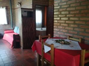 comedor con mesa y mantel rojo en Cabañas Valentina en Cortaderas