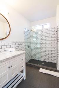 Baño blanco con lavabo y espejo en Penthouse Two at World Artists Living en Los Ángeles