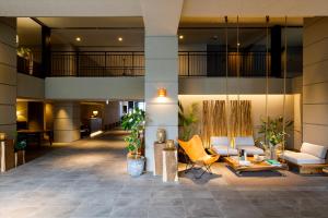 a lobby of a building with couches and chairs at Glamday Style Okinawa Yomitan Hotel & Resort in Yomitan