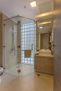 a bathroom with a glass shower and a sink at Valero Grand Suites by Swiss-Belhotel in Manila