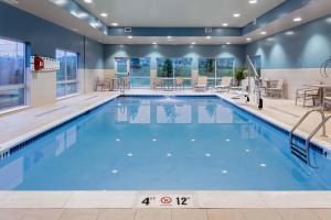a pool in a hotel room with a large swimming pool at Holiday Inn Express & Suites - Madison, an IHG Hotel in Madison