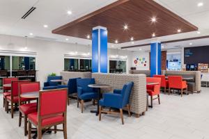 um restaurante com mesas e cadeiras vermelhas e azuis em Holiday Inn Express & Suites - Madison, an IHG Hotel em Madison