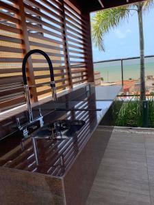 a kitchen sink with a view of the ocean at Flat UNO proximo ao mar in João Pessoa