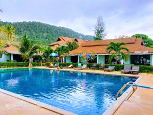 a swimming pool in front of a house at Banana Beach Resort in Ko Lanta