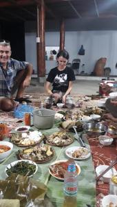 a group of people sitting around a table full of food at Shan Tea Homestay in Ha Giang