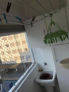 La salle de bains est pourvue de toilettes et d'une araignée suspendue au plafond. dans l'établissement apartamento próximo a praia da Enseada, à Guarujá