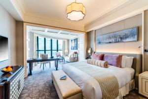 een hotelkamer met een groot bed en een bureau bij Caravelle Saigon in Ho Chi Minh-stad