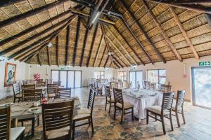 a dining room with tables and chairs in a building at Ritsako Game Lodge in Klipdrift