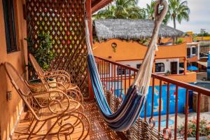 two hammocks on a balcony with chairs and a pool at Hotel Posada Luna Sol in La Paz