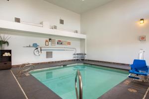 a swimming pool with a blue chair in a room at Sandia Peak Inn, a Howard Johnson by Wyndham in Albuquerque