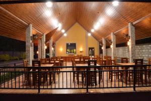 a restaurant with wooden tables and chairs and lights at Monarch Residence in Polonnaruwa