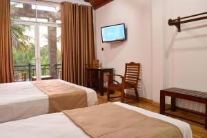 a hotel room with two beds and a flat screen tv at Monarch Residence in Polonnaruwa