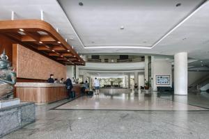 a lobby with people standing at a counter in a building at Loei Palace Hotel in Loei