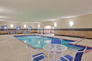 una piscina con sillas y una mesa en una habitación de hotel en Holiday Inn Express Hotel & Suites Dumas, an IHG Hotel, en Dumas