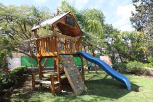 une aire de jeux avec une cabane dans les arbres et un toboggan dans l'établissement Belisana, à Ixtapan de la Sal