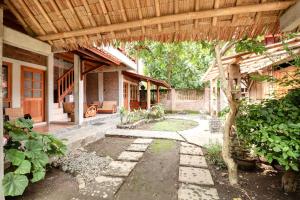 una vista esterna di una casa con un albero di Saka Homestay Boutique & Cafe a Borobudur