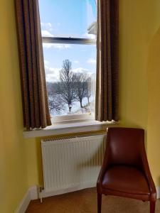 una silla sentada frente a una ventana en Strathness House, en Inverness