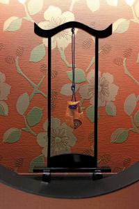 a clock that is hanging on a wall with flowers at Matsui Honkan in Kyoto