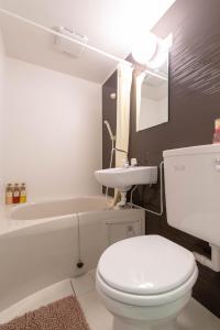 a bathroom with a toilet and a sink and a tub at BEEHIVE APARTMENT Moriguchi in Osaka