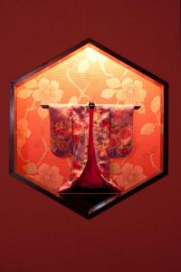 a lamp with two red vases on a wall at Matsui Honkan in Kyoto