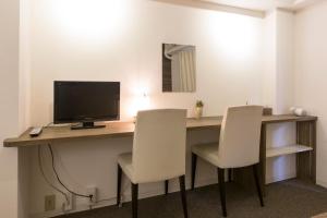 a room with a desk with a computer and two chairs at BEEHIVE APARTMENT Moriguchi in Osaka