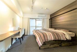 a bedroom with a bed and a desk and a desk at BEEHIVE APARTMENT Moriguchi in Osaka +55 photos