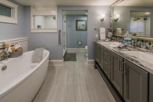 Holiday Inn Club Vacations Cape Canaveral Beach Resort, an IHG Hotel في كيب كانافيرال: حمام به مغسلتين ومرآة كبيرة