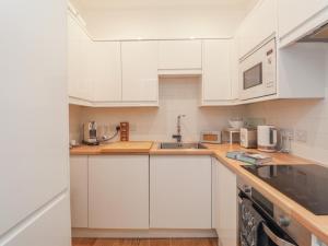 a white kitchen with white cabinets and appliances at Mount Sion in Royal Tunbridge Wells