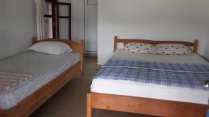 ein Schlafzimmer mit zwei Betten und einem Fenster in der Unterkunft Cennet Pansiyon in Kaleucagız