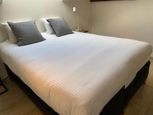 1 cama blanca grande con 2 almohadas en Burgstraat 17 Apartment in Exclusive Patrician House in Medieval Ghent, en Gante