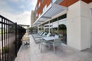 a patio area with chairs, tables, and umbrellas at Holiday Inn Express & Suites Fond Du Lac, an IHG Hotel in Fond du Lac