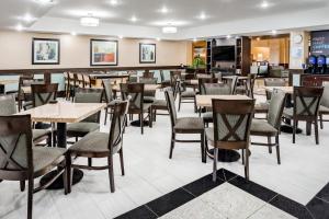 un comedor con mesas y sillas en un restaurante en Holiday Inn Express Hotel & Suites Canton, an IHG Hotel, en Canton