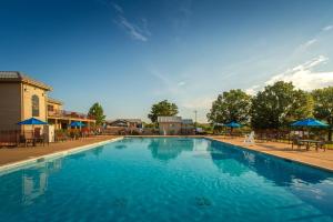 a large blue swimming pool with tables and umbrellas at Holiday Inn Club Vacations Timber Creek Resort at De Soto in Papin