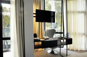 a room with a desk with a television and a chair at River View Hotel Tbilisi in Tbilisi City