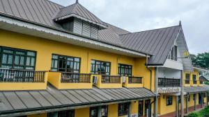 a yellow building with a black roof at Gregoire's Apartment in La Digue