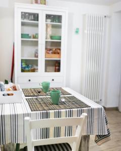 tavolo da pranzo con due ciotole verdi di Casa vacanza LA MIA CASETTA SUTRI a Sutri