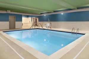 a large swimming pool with blue water in a building at Holiday Inn Express & Suites - Cincinnati South - Wilder, an IHG Hotel in Wilder