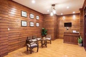 Habitación con pared de madera, mesa y sillas. en Primmalyn บ้านพริมมาลีณ en Chiang Khan