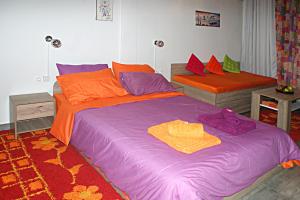 a bedroom with a large bed with orange and purple sheets at Sunny studio with Parthenon view balcony in Athens