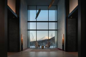 a room with two chairs and a table in front of a large window at Park Hyatt Niseko Hanazono in Kutchan