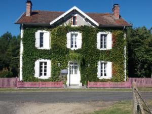a house covered in ivy on a street at Les Eygletières in Bourriot-Bergonce