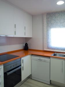 a kitchen with white cabinets and a stove top oven at Cal Negri in Vilafranca del Penedès