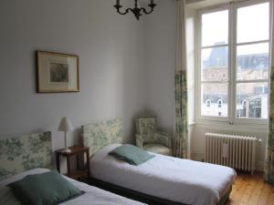 1 dormitorio con 2 camas y ventana en Chambre d'Hôtes Marchand, en Angers