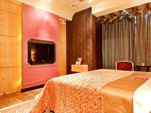 Een bed of bedden in een kamer bij Zheng Yi Hotel & Motel I