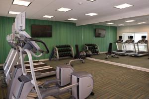 a gym with several tread machines and green walls at Holiday Inn Express & Suites - Marietta by IHG in Marietta +22 photos